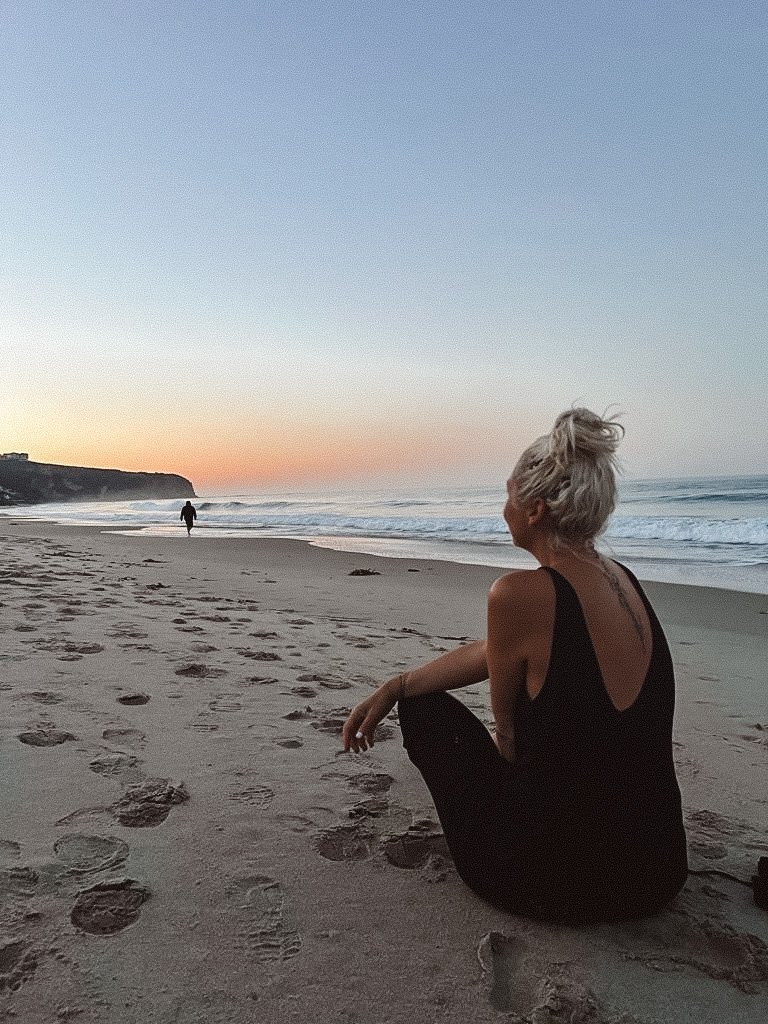 Alexandra Recordon assise sur la plage au coucher du soleil